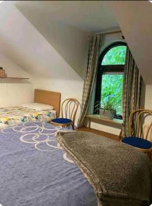 a bedroom with a bed and two chairs and a window at CASTLETON in Belfast +10 photos