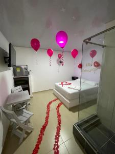 une chambre avec des ballons roses sur le mur et un lit dans l'établissement Hotel ZT, à Mariquita