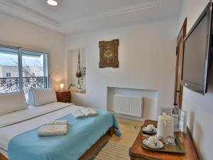 a bedroom with a bed and a tv and a table at Dar Souad in La Marsa