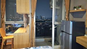 a kitchen with a view of a city skyline at Studio17 Elpis Kemayoran JIEXPO Sunrise View -Min Stay 3 nights- in Jakarta