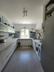 a large kitchen with a refrigerator and a window at Maison pieds dans l eau St Florent in Saint-Florent