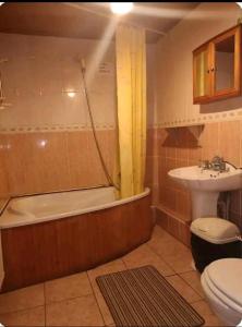 a bathroom with a tub and a toilet and a sink at CASTLETON in Belfast
