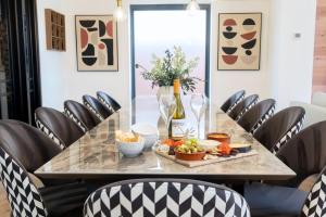 a table with a bottle of wine and a plate of food at Elliot Oliver - Superior 6 Bedroom House in Cheltenham With Hot Tub & Log Burner in Cheltenham