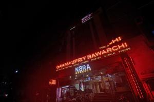 a building with neon signs on it at night at Townhouse Hotel Nera Regency Near Image Hospital in Kondapur