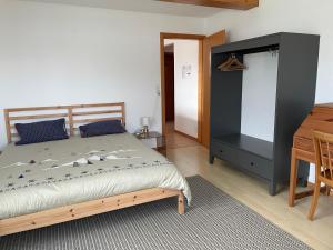 sypialnia z łóżkiem i biurkiem obok stołu w obiekcie Les Rossets w mieście Boudry