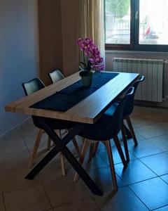 une table en bois avec des chaises et une plante en pot. dans l'établissement Il Sole Dentro Holiday Home, à Pellezzano
