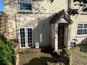 a white house with a door and a window at Antic Cottage for Family in Nottingham