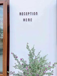 a sign on the side of a door with a plant at Lac House Mui Ne in Mui Ne