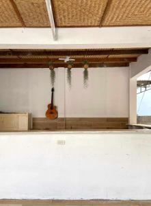 une guitare assise sur le mur d'une pièce dans l'établissement Lac House Mui Ne, à Mui Ne