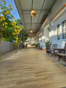 une terrasse couverte vide d'un bâtiment avec bancs et arbres dans l'établissement Lac House Mui Ne, à Mui Ne