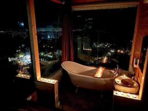 een badkamer met een bad en een raam bij mimosa villa tam dao in Tam Ðảo