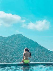 een vrouw in het water met een berg op de achtergrond bij mimosa villa tam dao in Tam Ðảo