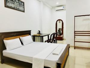 a bedroom with a bed and a table and a chalkboard at Eco Resort Kandy in Kandy