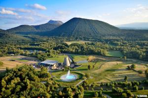 una vista aérea de una granja con una fuente y montañas en F2 Lumineux avec vue- Puy-de-Dôme à 10 min - Parking gratuit, en Royat