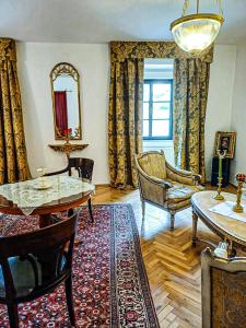 a living room with a table and chairs and a mirror at Schloss Süßenstein in Hüttenberg