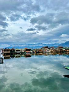 una gran masa de agua con casas y montañas en Houseboat Newworld and transportation en Srinagar