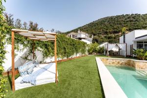 a garden with a pergola and a swimming pool at Villa Sueños in Mijas