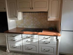 a kitchen with white cabinets and a white refrigerator at Antic Cottage for Family in Nottingham +3 photos