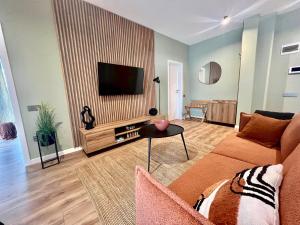 a living room with a couch and a flat screen tv at Rhodium Apartment in Cluj-Napoca