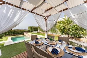 an outdoor dining area with a table and chairs and a pool at Villa Sueños in Mijas