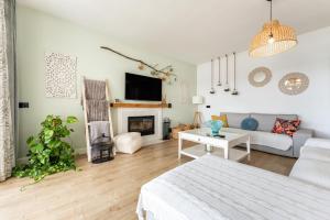 a white living room with a bed and a fireplace at Villa Sueños in Mijas