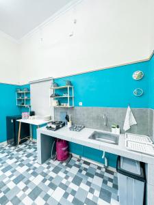 a kitchen with a sink and a blue wall at OsCo Paviliun in Yogyakarta +63 photos