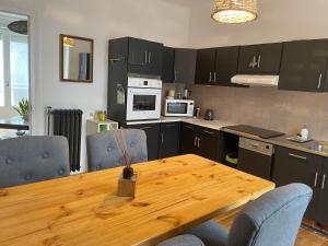 a kitchen with a wooden table and some chairs at Ty Sarah Lomener Beach appartement in Lomener