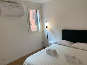 een witte slaapkamer met een bed met twee handdoeken erop bij appartamento con cortile in Venetië