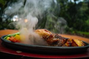 a plate of food with smoke coming out of it at Rock n Fall Nature Resort in Ella