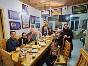 Un groupe de personnes assises autour d'une table dans l'établissement Huy Trung Homestay, à Bắc Hà