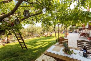 una mesa de picnic bajo un árbol en un patio en Petalidi Stone House with garden near the beach, en Petalidi