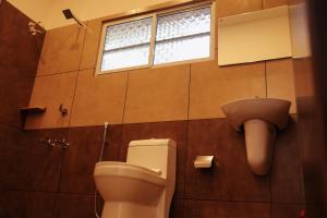 马拉利库兰RIVA Marari Beach Homestay的带马桶和窗户的浴室