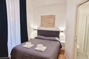 een slaapkamer met een bed met twee witte handdoeken erop bij Oasi Guest House in Rome