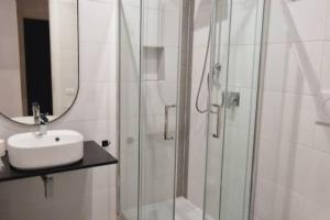 een badkamer met een douche, een wastafel en een spiegel bij Oasi Guest House in Rome