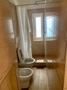 een badkamer met een toilet, een wastafel en een douche bij appartamento con cortile in Venetië