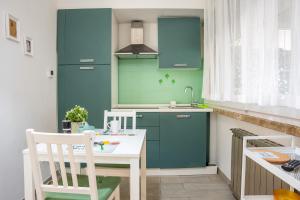 a kitchen with blue cabinets and a white table at La casetta di Ella in Pisa