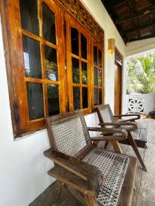 una veranda con due sedie, un tavolo e una finestra di Varan Mawella Beach Guest House a Tangalle