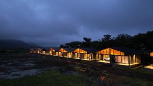 a row of lodges in a field at night at Shreephal luxurious Resort- Best resort in saputara in Saputara