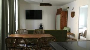 a living room with a green couch and chairs at Villa Sérénité appartement au centre ville n 4 in Lourdes