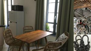 a dining room with a table and chairs and a refrigerator at Villa Sérénité appartement au centre ville n 4 in Lourdes