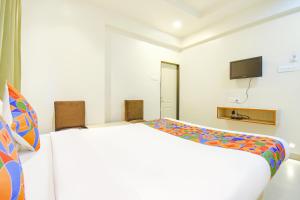 プネにあるFabHotel Ananta Sagarの白い部屋(ベッド1台、テレビ付)