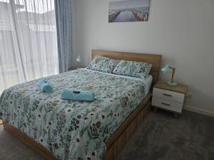 a bedroom with a bed with a blue suitcase on it at Tui Nest Garden Unit in Silverdale