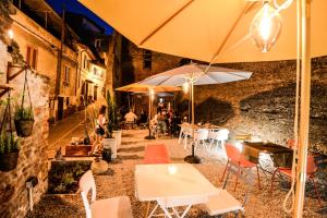 Santa Maria a MonteにあるART SUITE GALLERY - Tuscany - medieval town close to Florence, Pisa, Lucca, Chianti Zone, Versiliaのテーブルと椅子とパラソルのあるレストラン