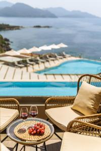 Sivota Diamond Spa Resort في سيفوتا: طاولة مع كأسين من النبيذ بجوار حمام السباحة