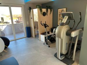 a gym with a treadmill and exercise bikes in a room at OliVia Home Sauna & Gym in Forlì