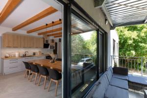 a kitchen and dining room with a large sliding glass window at Apartmán Smraďavka in Buchlovice