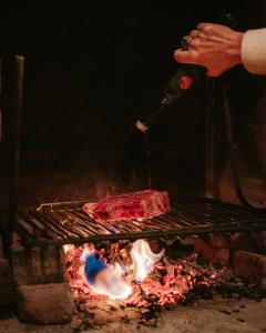 eine Person, die ein Steak auf einem Grill kocht in der Unterkunft Le Saint Urbain in Nollevaux
