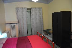 1 dormitorio con cama roja y ventana en Green House, en Génova