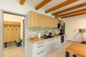 a kitchen with white cabinets and a wooden counter top at Apartmán Smraďavka in Buchlovice