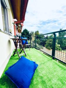 a balcony with blue pillows on the grass at Anna's Residency - Prestige Suite in Balatonkenese